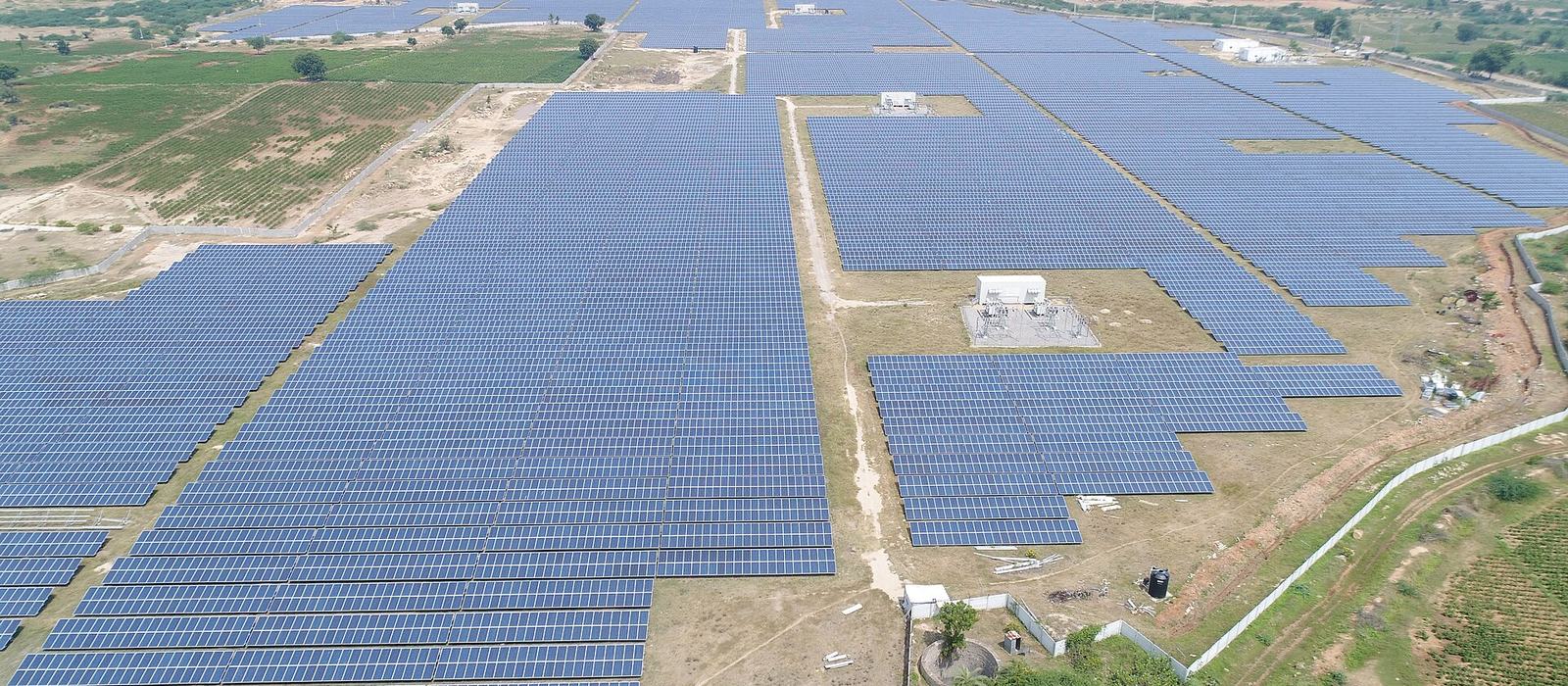 Rows of solar panels on mounting structures at an Indian solar plant